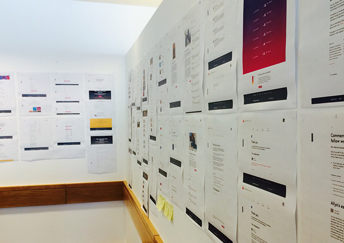 A photograph of two walls papered in printouts of modules and naming discussions.